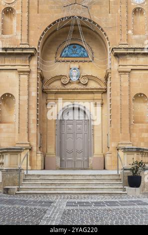 Marsaxlokk, Malta, 01 07 2022: Facade with an arched entrancer door of the cathedral, Europe Stock Photo