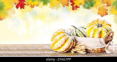 Autumn-themed food arrangement with pumpkins and autumn leaves on a table, creating a cozy seasonal atmosphere Stock Photo