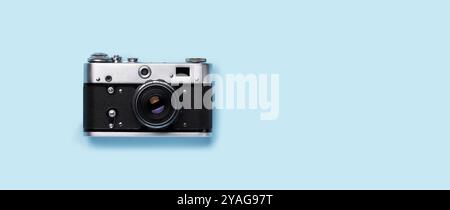 A vintage retro camera placed flat on a bright blue background, capturing the essence of old-school photography Stock Photo