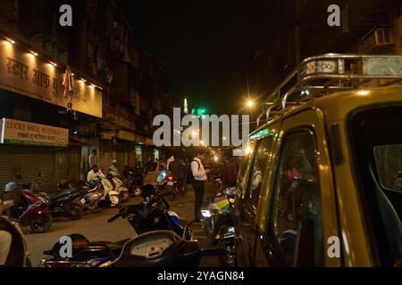 Trying food at Bohri Mohalla in Mumbai during Ramzan, with a man checking reviews on his phone Stock Photo