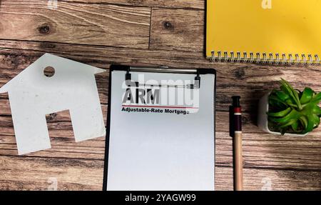 Concept of ARM - Adjustable-Rate Mortgage write on paperwork isolated on wooden background. Stock Photo