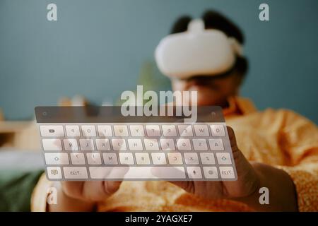 Low angle shot of senior woman with headset typing on transparent VR presentation Stock Photo