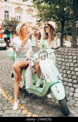 Two friends drinking coffee in Italy in a nice courtyard in summer Stock Photo