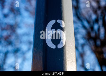 white number six printed and painted on green street lamp Stock Photo