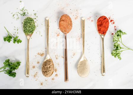 Five different spices in spoons on a table Stock Photo