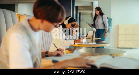 Students in a high school study centre engaged in effective study sessions using books and laptops, while enjoying collaborative and productive atmosp Stock Photo