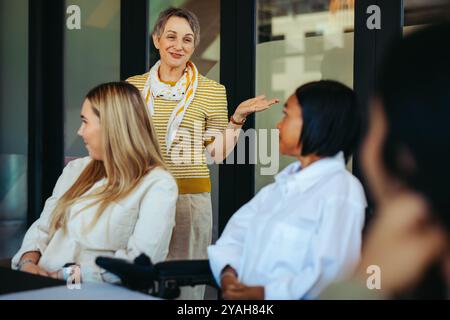 A dynamic teacher interacting with a small class, creating a positive and inclusive learning atmosphere with attentive and diverse students. Stock Photo