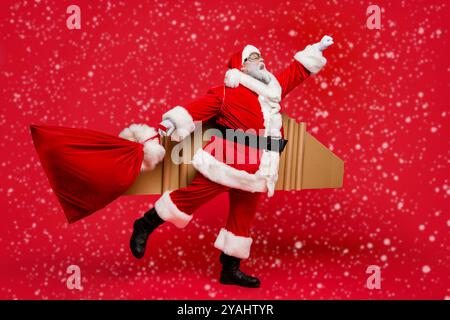 I give you wish whatever it takes Full size photo of crazy funky smile retired space man in christmas father costume hurry fly up to deliver gifts Stock Photo