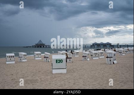 28.07.2024, Germany, Mecklenburg-Western Pomerania, Heringsdorf - Europe - Dark clouds move over the empty sandy beach and the pier at the Baltic Sea Stock Photo