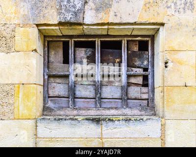 Blocked broken window in stone wall of old building - Le Petit-Pressigny, Indre-et-Loire (37), France. Stock Photo