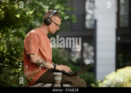 Medium shot of male IT developer concentrated on using laptop to write code Stock Photo