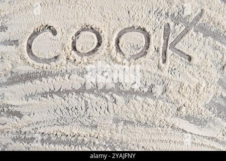 Grey cooking background of spilled wheat flour on stone background with text cook Stock Photo