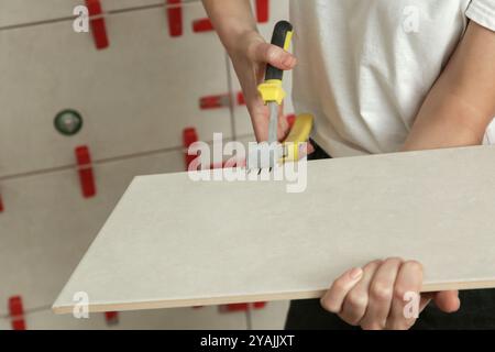 Worker cutting ceramic tile with ceramic tile cutter nipper. DIY home improvement project. Stock Photo