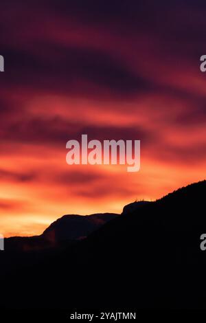 mountain sunset with red and orange clouds in val di fiemme Stock Photo
