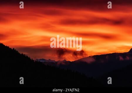 mountain sunset with red and orange clouds in val di fiemme Stock Photo