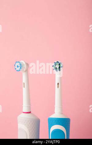 Two Modern electric toothbrushes on pink pastel background. Teeth care. Minimalism Stock Photo
