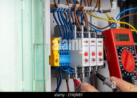 Electrician Testing Circuit Connections with Multimeter Stock Photo