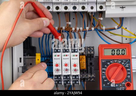 Electrician Using Multimeter to Test Electrical Connections Stock Photo