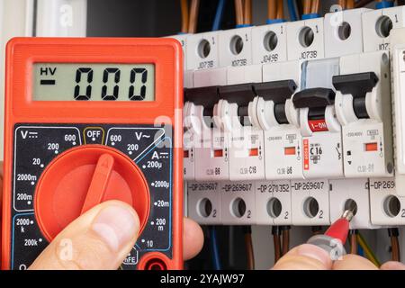 Electrician Testing Circuit Breaker with Multimeter Stock Photo