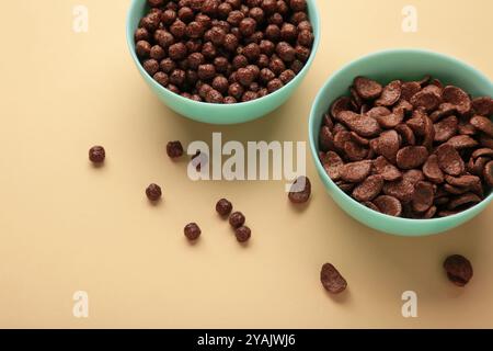 Different chocolate cereal corn in mint bowl on beige background. Copy, empty space for text. Stock Photo