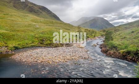 The waters of Loch Etive reflecting the surrounding mountains, with the snow capped peak of Ben Cruachan in the distance, Argyll and Bute, Scotland. Stock Photo