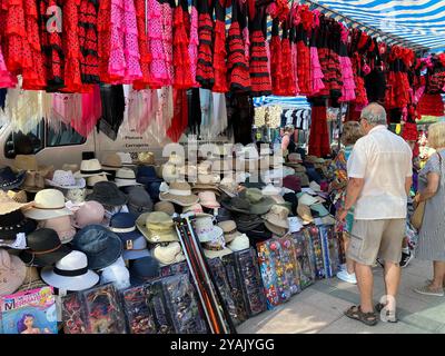 Group of elderly tourists at the Thursday Open Market looking at hats for sale on a stall Stock Photo