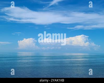A Florida Everglades seascape with calm waters reflecting the blue sky and scattered clouds, with small islands visible on the horizon. Stock Photo