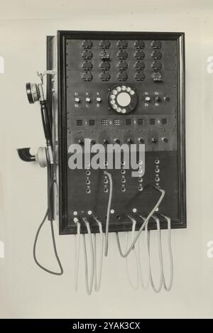 Vintage Swiss main switch for wall mounting, 1925 (Gfeller). Bümpliz, Switzerland. Changeover switch with switching cords. For the call signaling of the 20 internal lines, flaps with magnetic release are used. Stock Photo