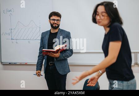 Teacher engaging with students in a dynamic classroom setting Stock Photo