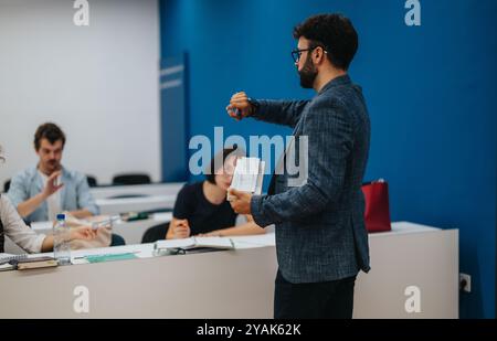 Professor assisting students during an engaging classroom session Stock Photo