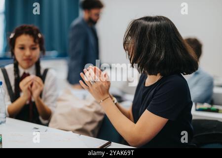 Students collaborating on tasks with guidance from a professor Stock Photo