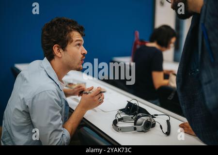 Students engaging in classroom tasks with professor guidance Stock Photo