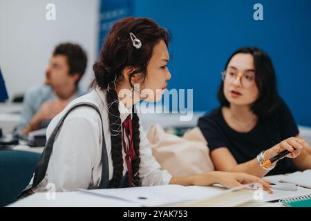 Engaged students collaborating on class tasks with professor assistance Stock Photo