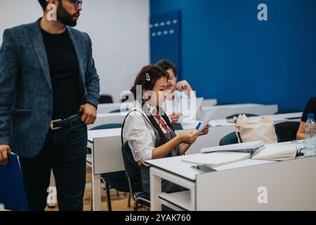 Professor assists students during a classroom task session Stock Photo