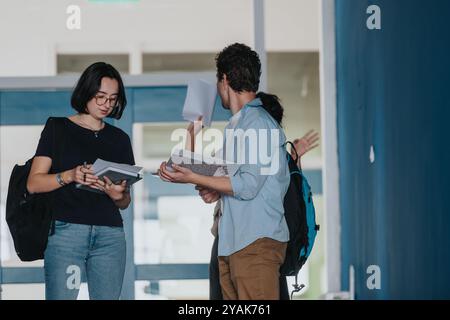 Students engaging with professor in university hallway discussion Stock Photo