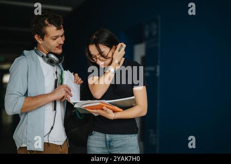 Two students discussing coursework in a hallway at university Stock Photo