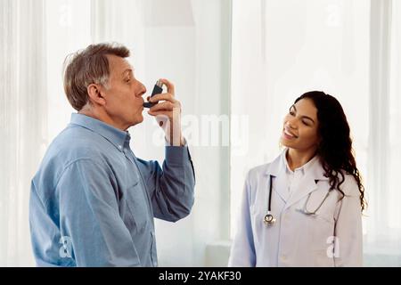 Physician examining mature man using blue asthma inhaler Stock Photo