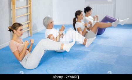 Women performing abdominal crunches with punches during self-defense course Stock Photo