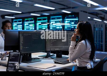 Team of experts in data center providing customer support, troubleshooting damages. Teamworking colleagues in server hub carrying out operational interventions requested by clients Stock Photo