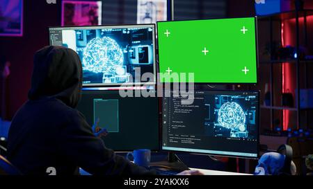Hacker using AI machine learning and isolated screen computer to produce malware corrupting data. Scammer working on chroma key PC using artificial intelligence tech, infecting systems, camera A Stock Photo