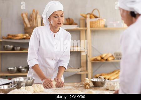 Female baker working diligently in a bakery Stock Photo