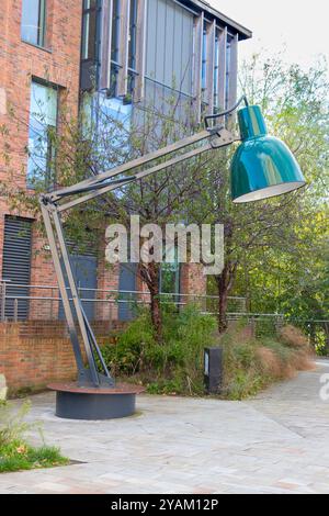 Giant green anglepoise lamp sculpture in urban outdoor setting against modern brick building and trees durham tyne & wear Stock Photo