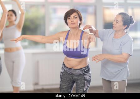 Elderly female ballet instructor teaching middle aged woman Stock Photo