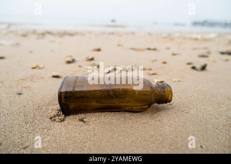 Empty glass bottles washed up on the beach Stock Photo