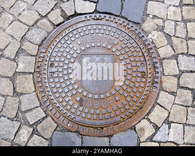 Hatch of sewage on the paving road in Tabor, Czech Republic, Europe Stock Photo