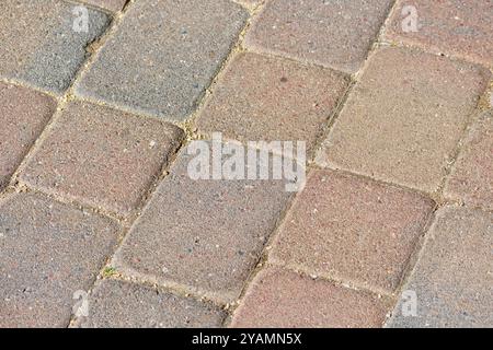 Patterned stone pavers with muted tones of beige and brown. Close up of interlocking stone pavers. Stock Photo