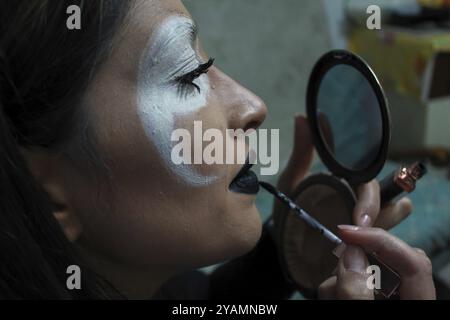 Close-up of woman doing scary makeup to celebrate Halloween or Day of the Dead Stock Photo