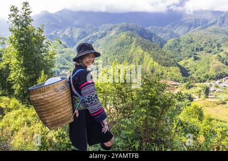 SAPA, VIETNAM, NOVEMBER 16: Vietnamese female from Hmong ethnic minority group in national dress hiking in mountains at November 16, 2016 in Sapa, Vie Stock Photo