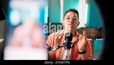 Live streaming, vlog and portrait of man talking with microphone with podcast for tech advice in home recording studio. Online, influencer and content Stock Photo