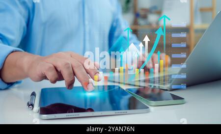Businessman use tablet showing a growing virtual hologram of analytics dashboard with charts, Stock market, Business growth, Progress or success conce Stock Photo